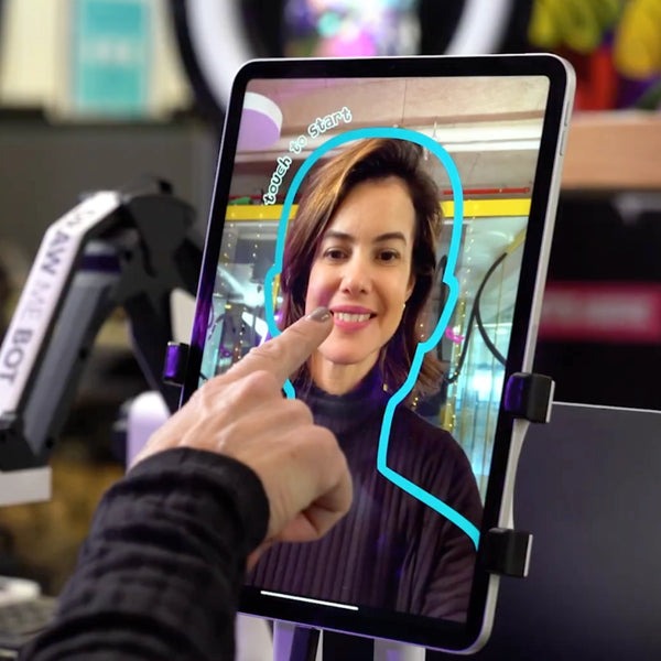 Trade show attendee stepping up to the Robo Portraits tablet