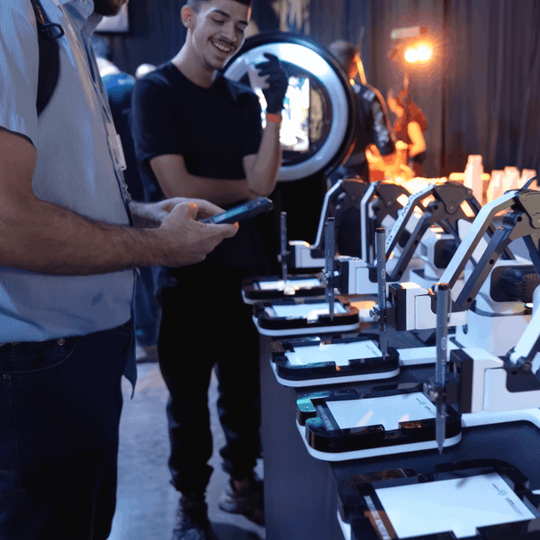 Crowd gathered watching Robo Portraits robot draw live at a trade show booth