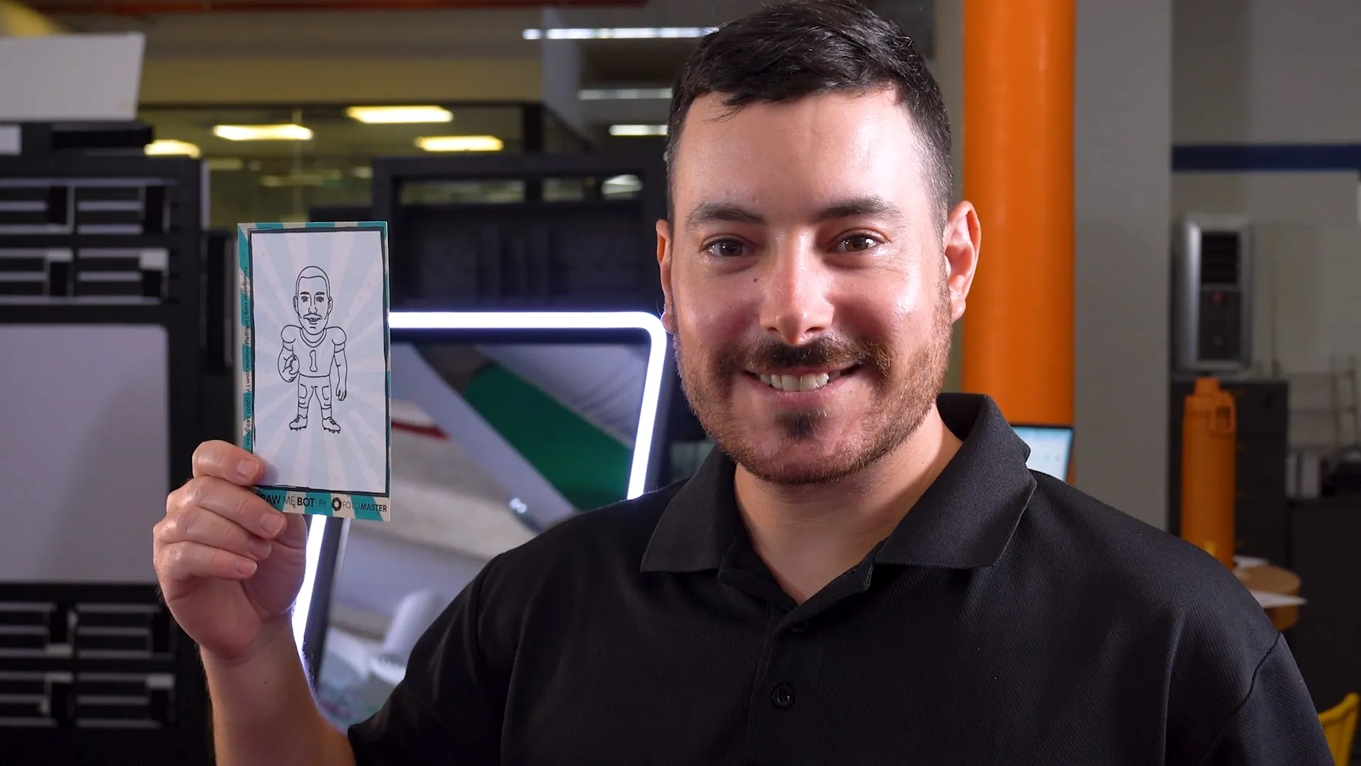 Man smiling and holding up a pen-drawn caricature card