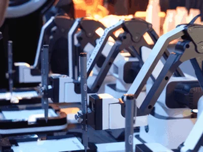 Robot arms holding pens over blank cards